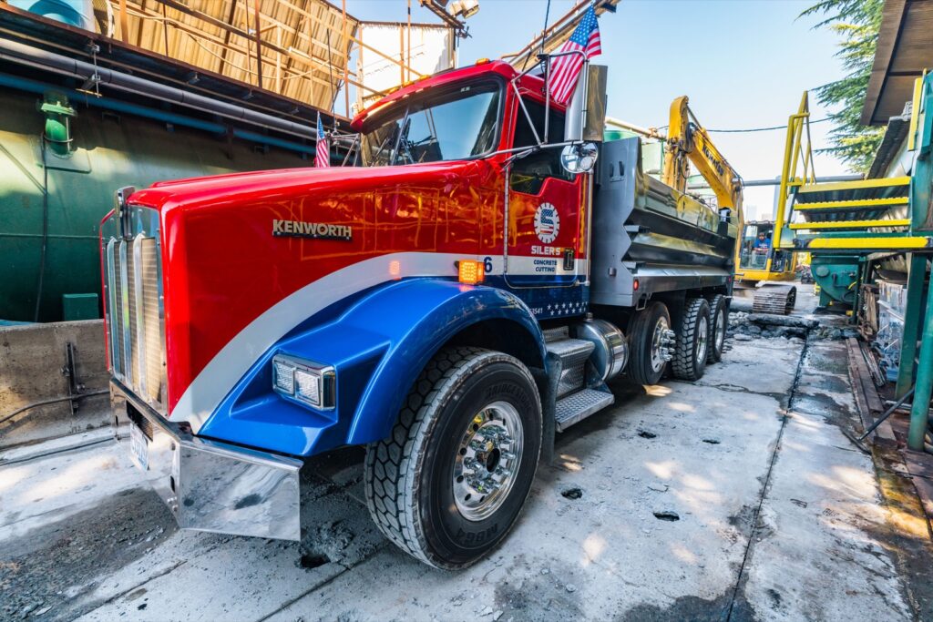 Siler's red, white and blue dump truck loaded with concrete on site