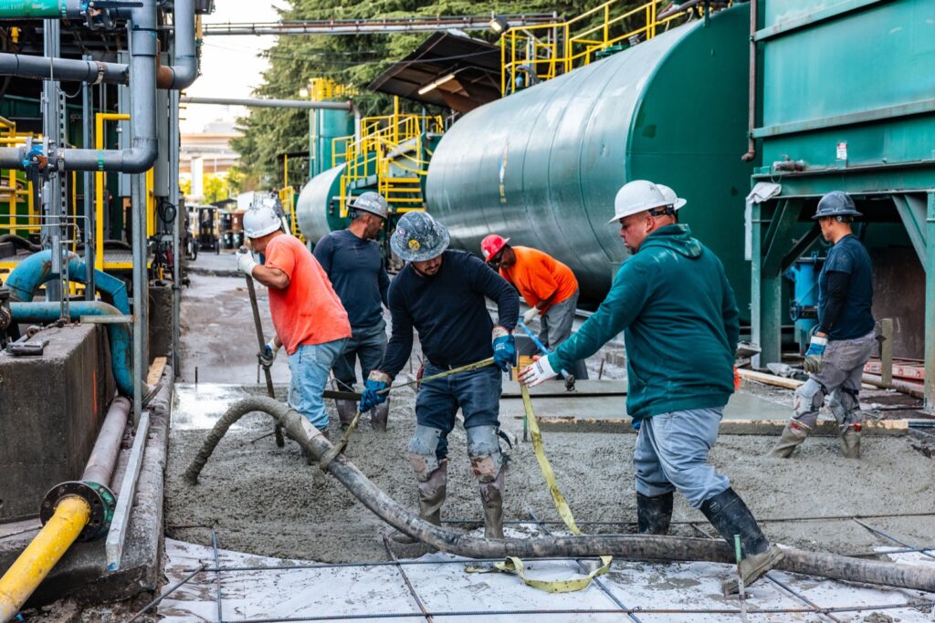 Crew placing concrete with a pump hose